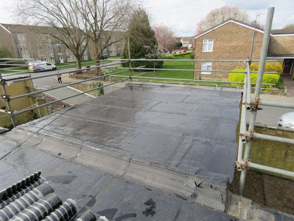 Dakdekkers aan het werk op plat dak met valbeveiliging